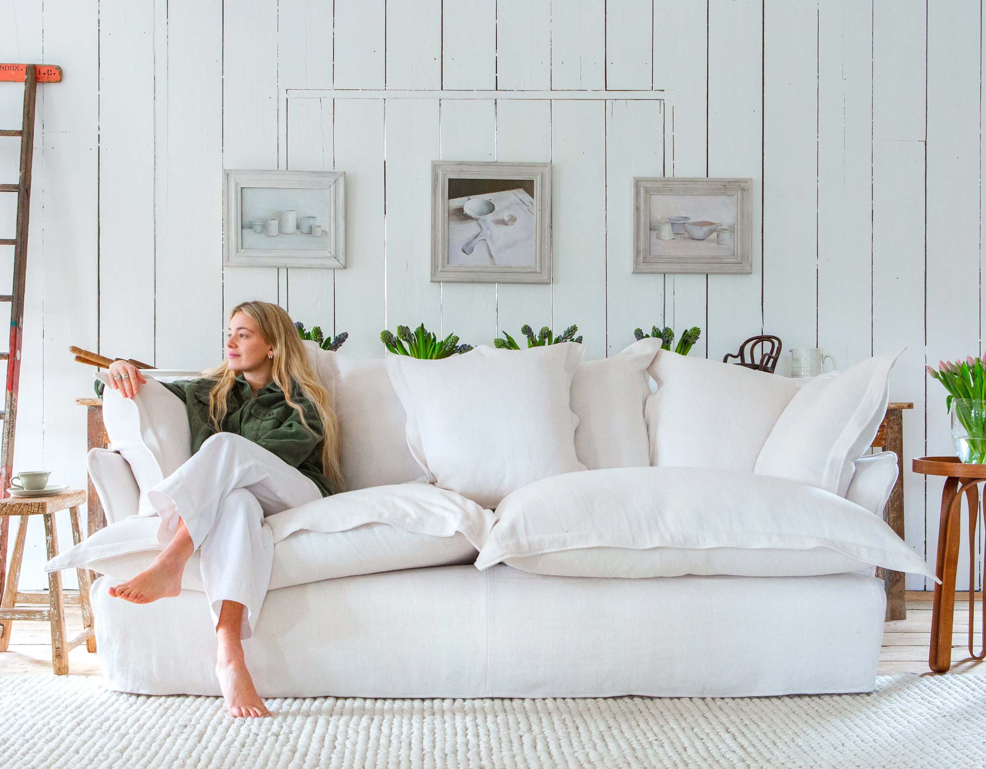 Marnie sitting on a Moonstone white Italian Linen, Song pillow edge, scatter back Sofa by Maker and Son